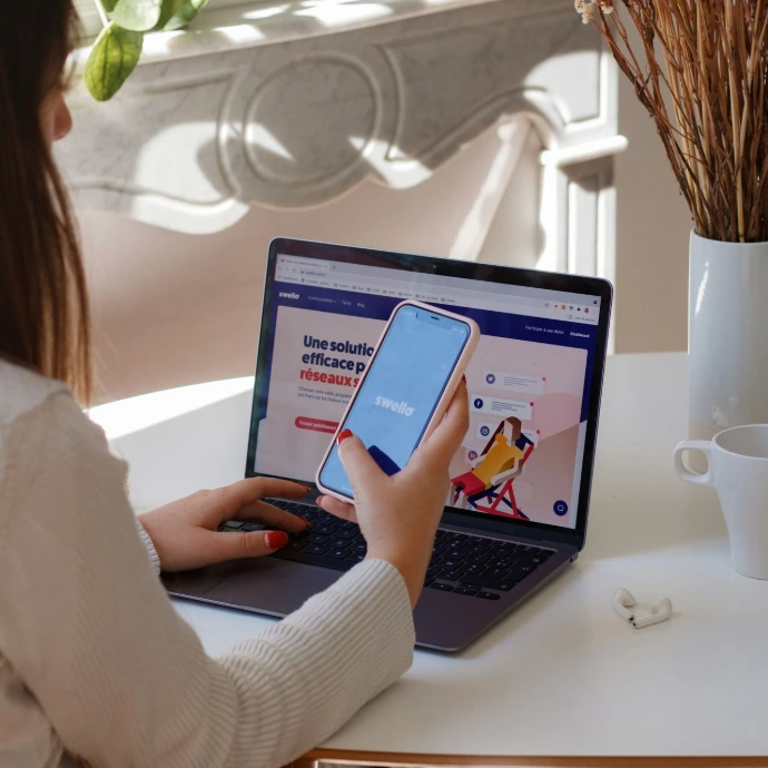 a woman sitting at a table using a laptop computer